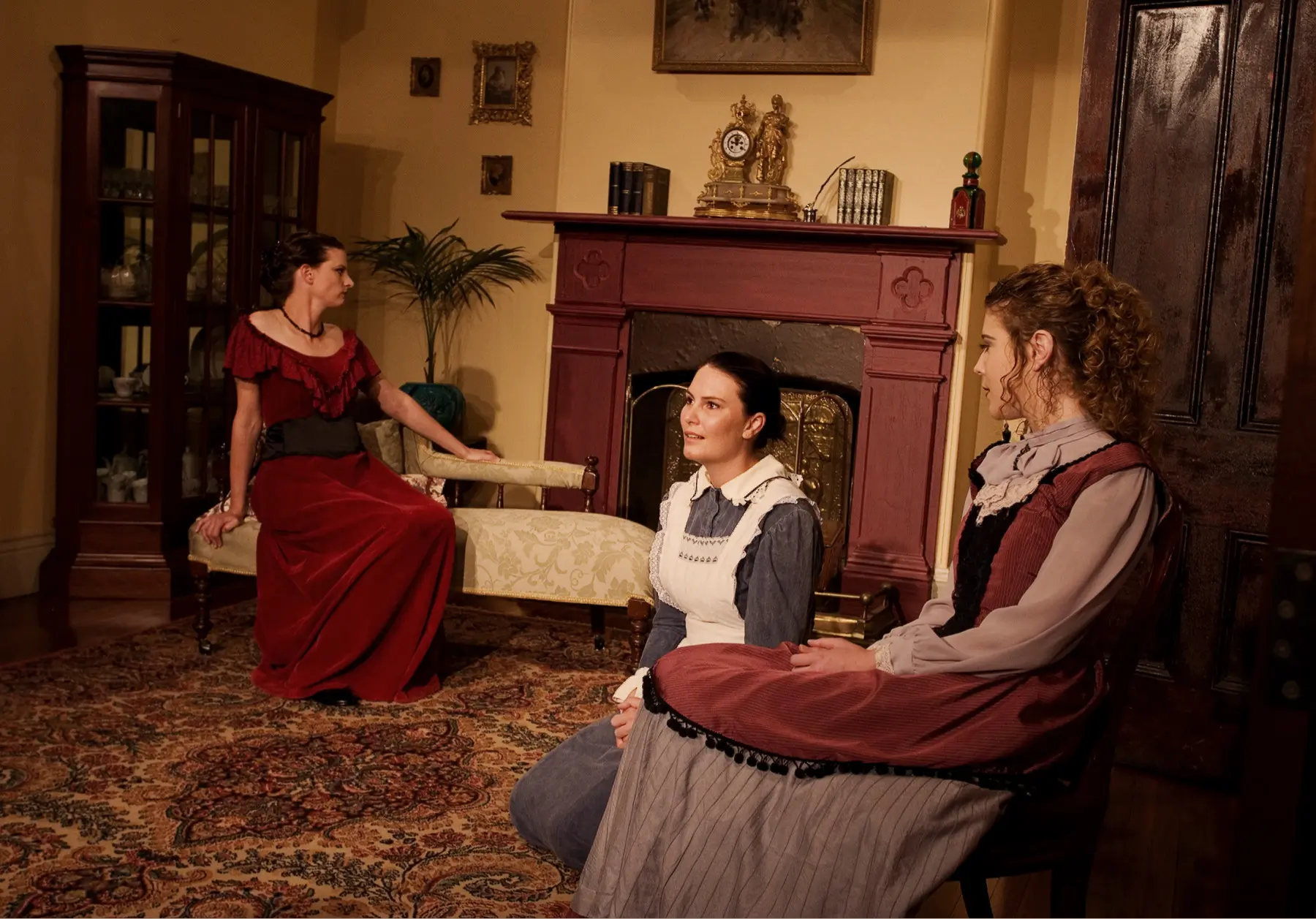A theatre set; three women in a drawing room.
